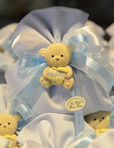 Bomboniera artigianale in stoffa azzurra con orsetto decorativo e fiocco bianco e azzurro, ideale per battesimo.