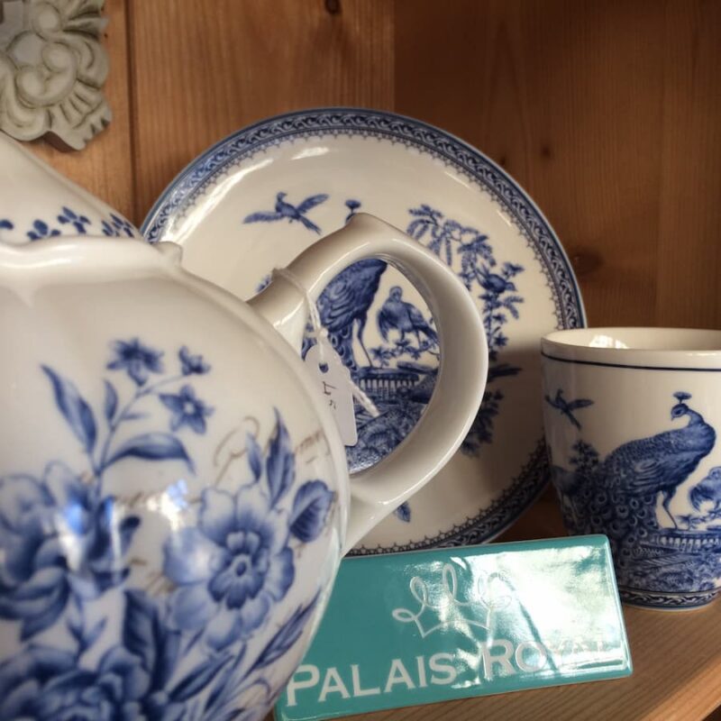 Teiera, piatto e tazza in porcellana bianca decorata con motivi floreali e pavoni blu