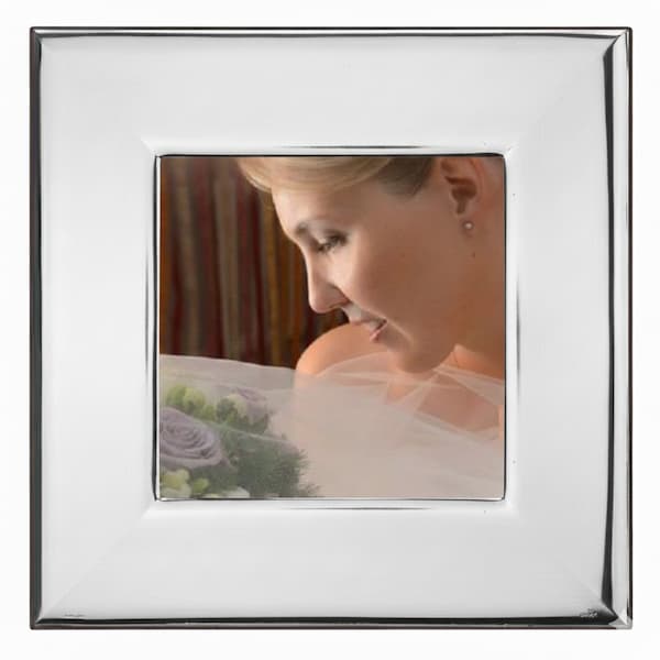 Cornice argentata con fotografia di sposa che osserva un bouquet di rose lilla e verde decorativo.