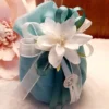 Sacchettini bomboniera matrimonio in organza bianca con confetti colorati, decorazioni fiocco gioiello e rosa in tessuto