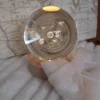 Globo in cristallo trasparente con incisione 3D del Sistema Solare, pianeti e orbite etichettate, illuminato da una base LED circolare in legno.