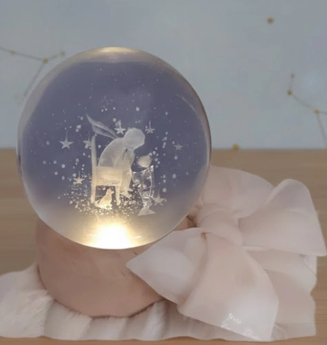 Sfera di cristallo 3D con incisione del Piccolo Principe seduto con la volpe su base in legno luminosa.