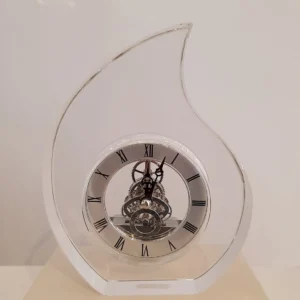 Orologio da tavolo a forma di goccia in cristallo con ingranaggi a vista e numeri romani, collezione Rinoldi.
